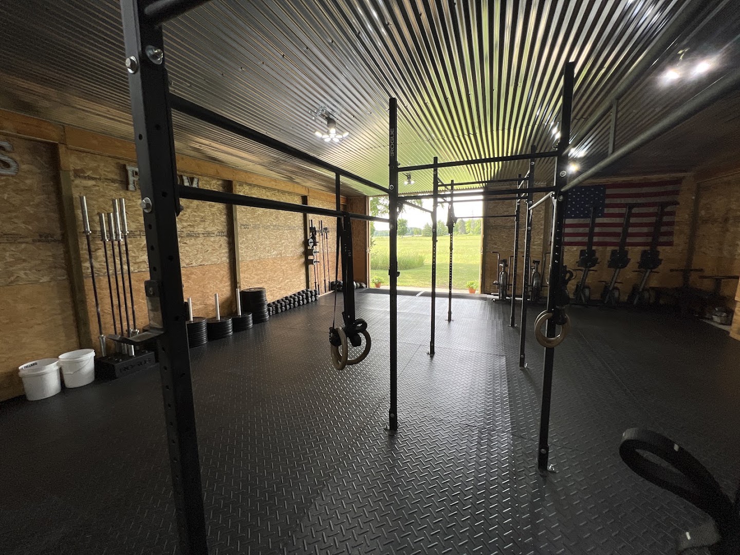 Rogue rig inside the Fitness Farm barn with the roll up door open onto a green field